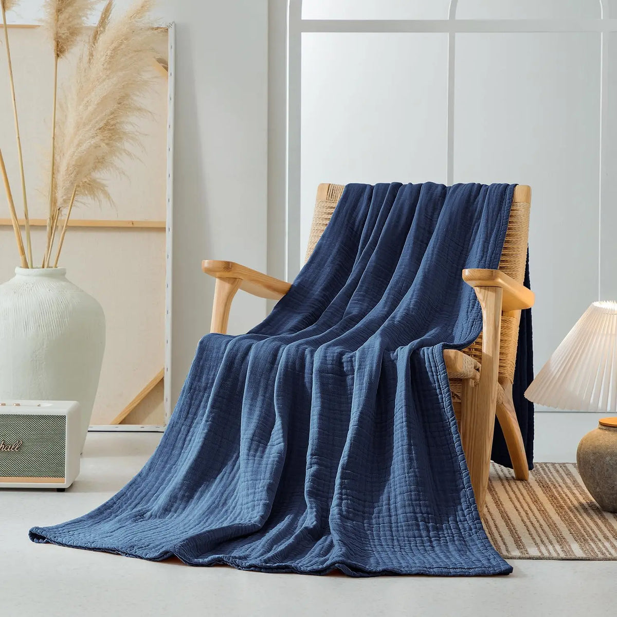 Navy Blue 100% cotton 6-layer muslin throw blanket draped over a wooden armchair in a styled living room
