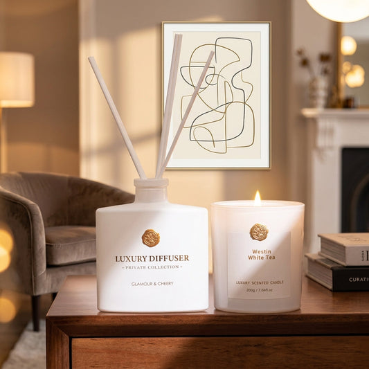 Luxury reed diffuser and scented candle styled on a wooden sideboard in a warm living room