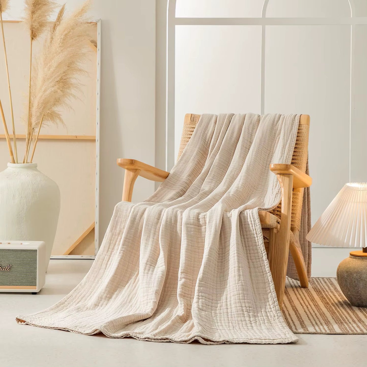 Sand Linen 100% cotton 6-layer muslin throw blanket draped over a wooden armchair in a warm styled living room