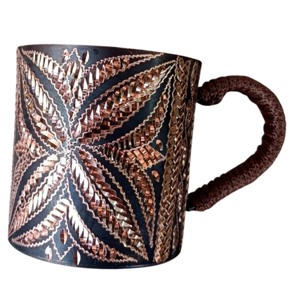 "Artisan's Mark" handcrafted copper mug held from below, full pattern detail — CL House