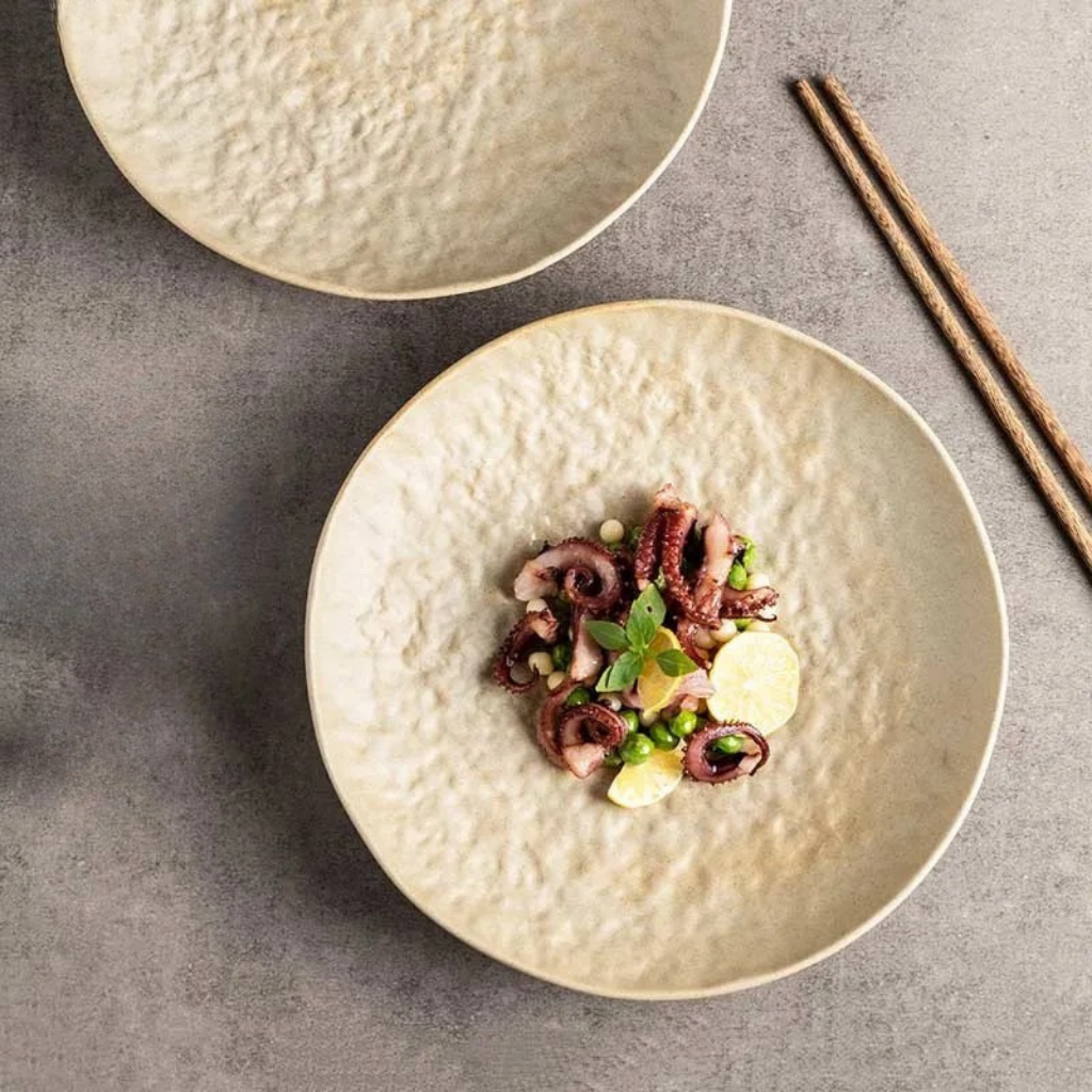 Stone Sand ceramic dinner plate with hammered texture, styled with gourmet food and chopsticks, top view