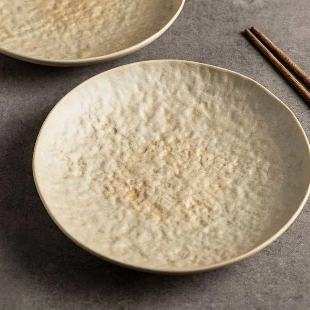 Close-up of handcrafted ceramic dinner plate showing hammered stone sand texture, 23cm artisan tableware