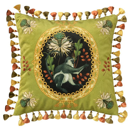 "Tropical Reverie" velvet cushion cover, Jungle Sovereign design — sage green ground with oval gold medallion, white bird and thistle bloom, floral corner embroidery, multicolour tassel trim