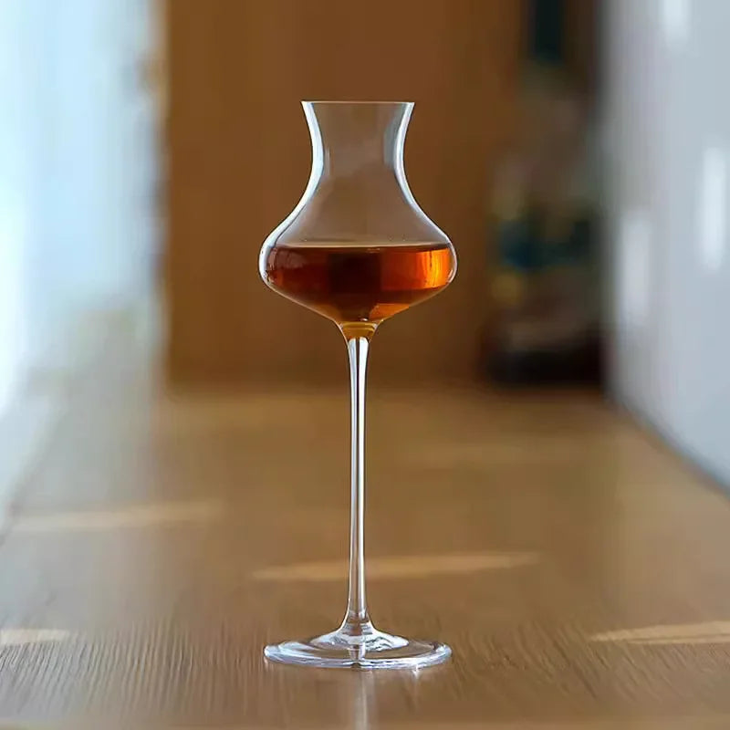  "Slender" crystal spirits glass filled with wine, placed on a table, sleek elongated silhouette — CL House Drinkware collection
