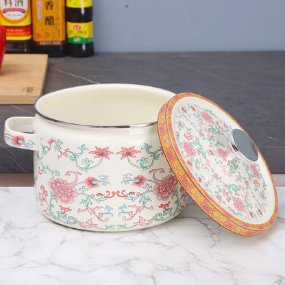 Floral enamel casserole open with lid resting beside it, Lotus Bloom design — showing deep cream interior and silver rim, pink lotus print exterior on marble surface — Peony Garden by CL House