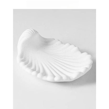  Chalk white matte ceramic shell-shaped soap dish, angled view on white background