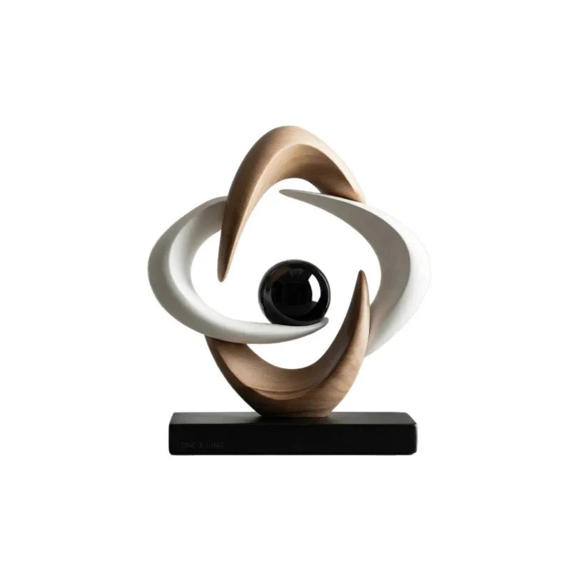 White and gold abstract resin sculpture with interlocking curved loops and a glossy black sphere on a black rectangular base, shown against a white background.