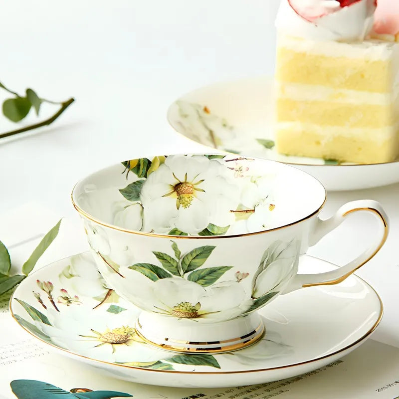 "White Camellia" fine bone china tea cup filled with golden tea, camellia floral design and gold rim — CL House & Home