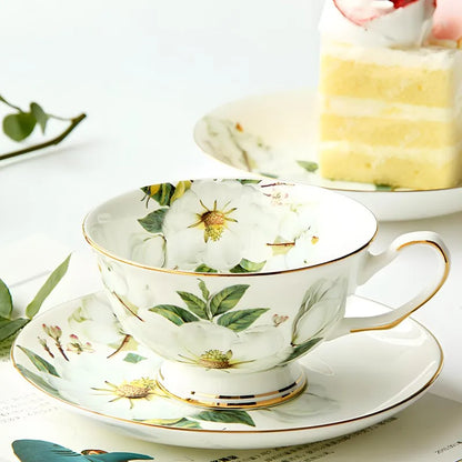 "White Camellia" fine bone china tea cup filled with golden tea, camellia floral design and gold rim — CL House & Home