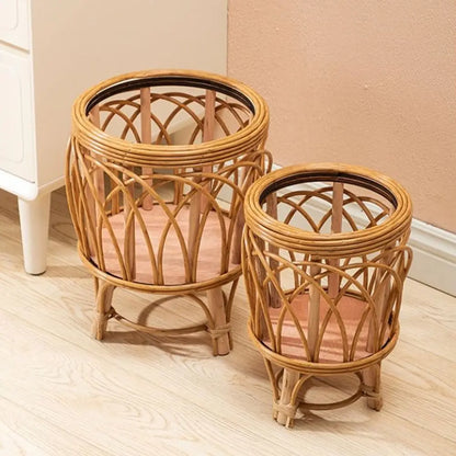 "Rattan Weave" natural rattan plant stands in Arch Weave Large and Small sizes styled together, glass top inserts, warm honey tone finish, against a terracotta wall on a light wood floor