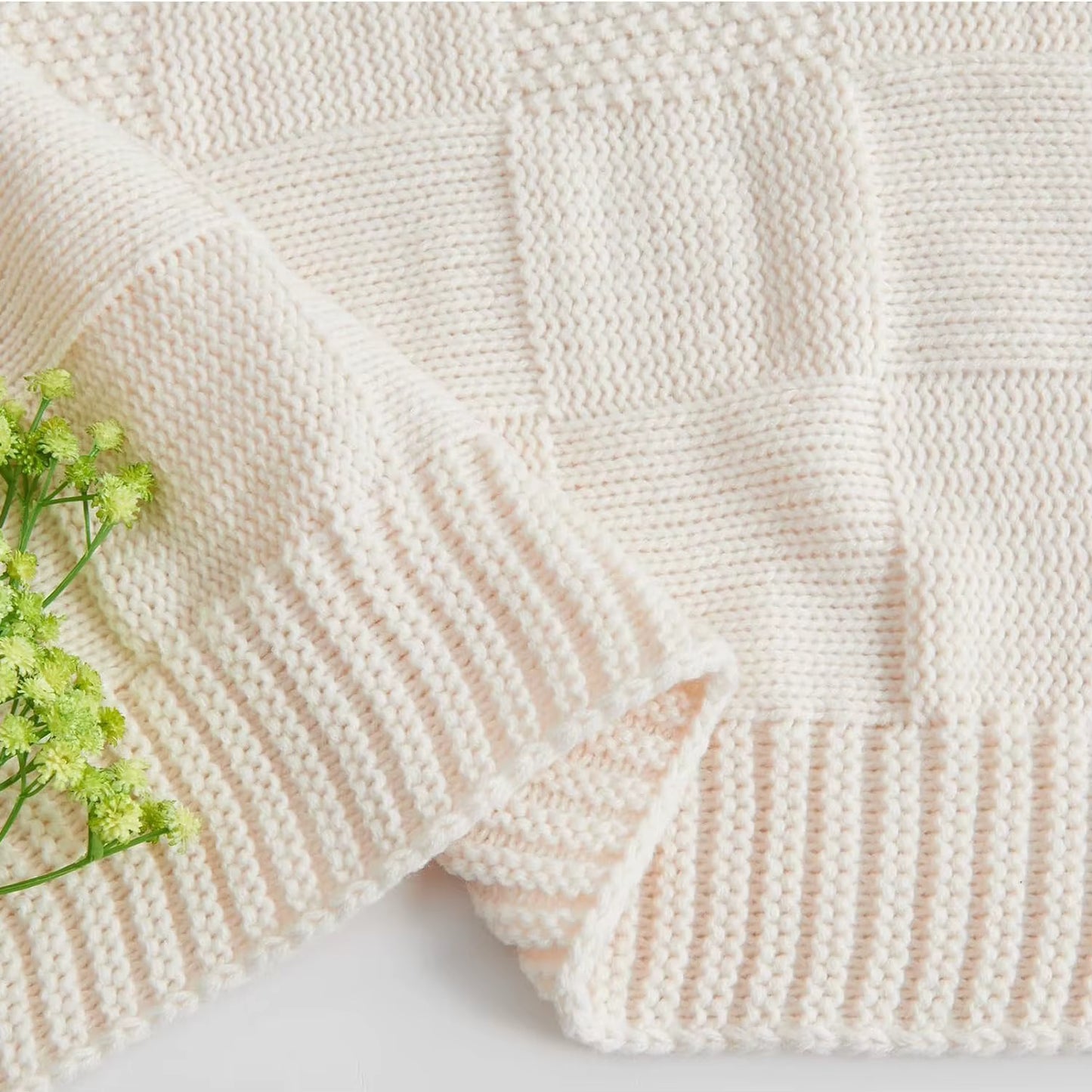 Close-up of chunky patchwork knit throw blanket in Ivory Cream — alternating basket weave and ribbed knit blocks with soft ribbed border detail