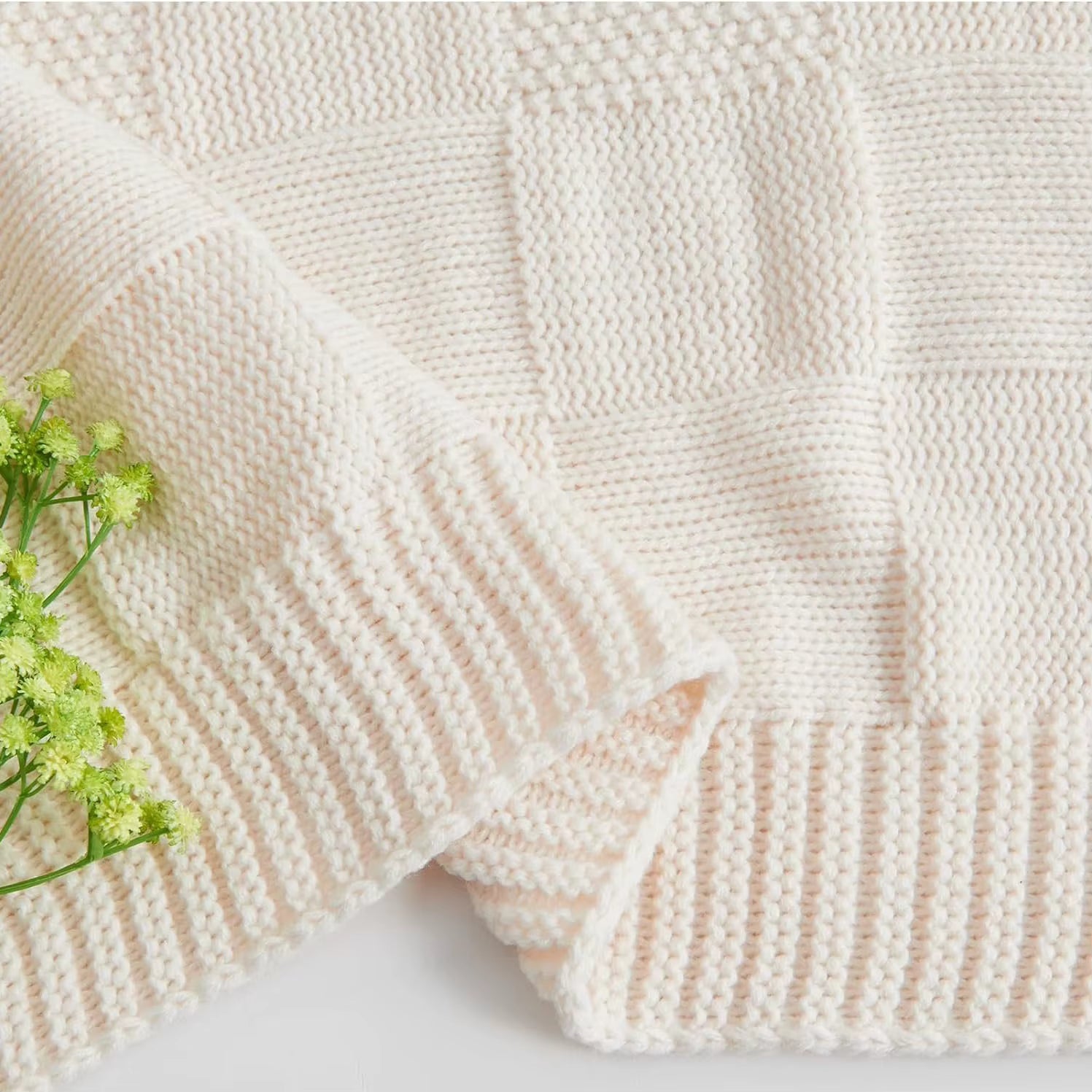 Close-up of chunky patchwork knit throw blanket in Ivory Cream — alternating basket weave and ribbed knit blocks with soft ribbed border detail
