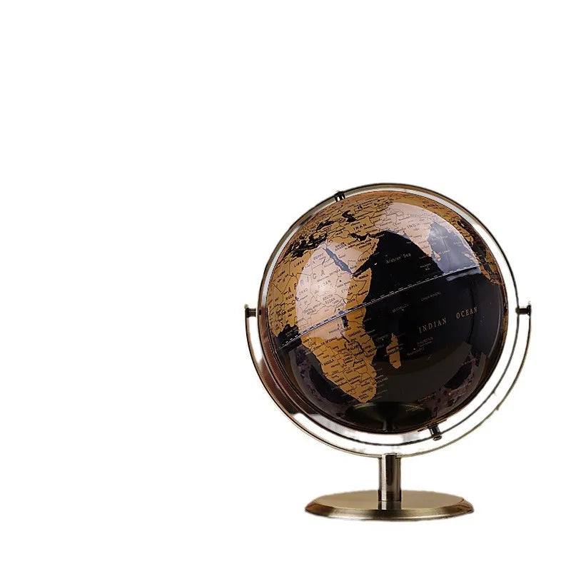 Decorative world globe with black and gold vintage map, gold-plated metal stand and ring frame, isolated on white background