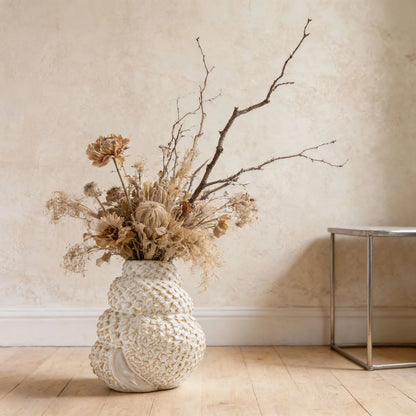  Coral Nest textured ceramic vase styled with dried protea and bare branches on wooden floor, textured wall background