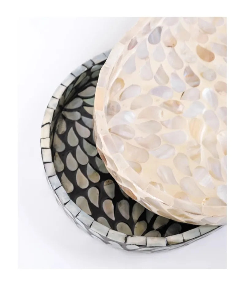 : Close-up macro detail of Pearl mother-of-pearl shell mosaic tray resting on Midnight tray, showing individual hand-placed iridescent shell pieces in cream and black — artisan craftsmanship detail