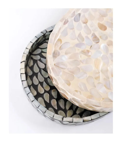 : Close-up macro detail of Pearl mother-of-pearl shell mosaic tray resting on Midnight tray, showing individual hand-placed iridescent shell pieces in cream and black — artisan craftsmanship detail