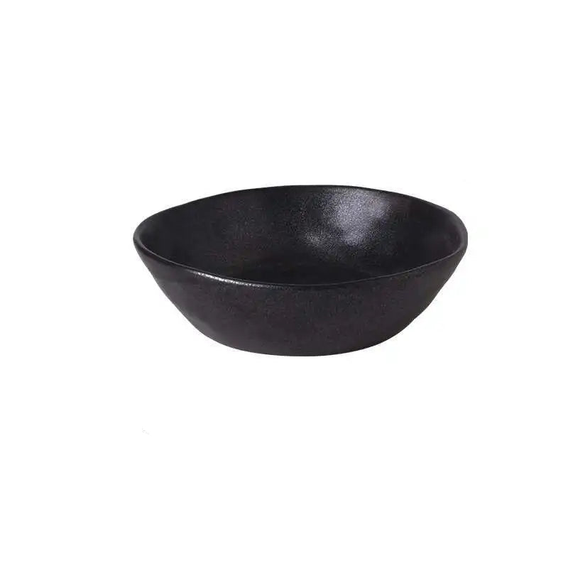  "Speckled Stone" ceramic serving bowl in matte black with speckled glaze texture — angled front view on white background