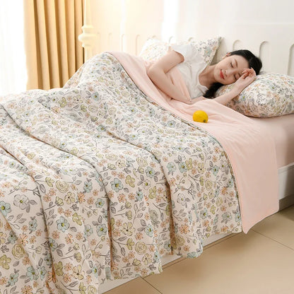 Blossom Sketch ice silk cooling summer quilt with delicate floral sketch print spread over a bed with blush pink fitted sheet