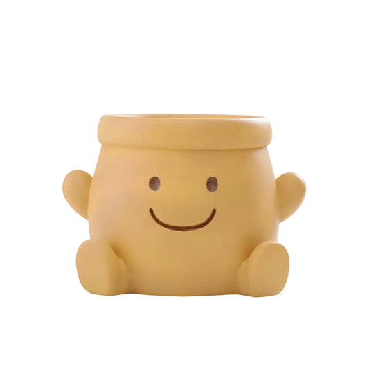 "Happy Pot" smiley face resin succulent planter in mustard yellow with open arms design and drainage hole, white background