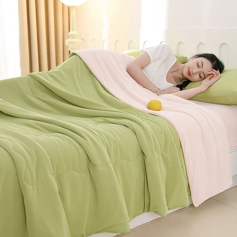 Sage & Blush reversible ice silk cooling summer quilt showing sage green and blush pink double-sided design on a bed