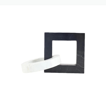 Square black and white interlocking marble sculpture with dimensions of approximately 23.5 by 15 by 15 centimetres.