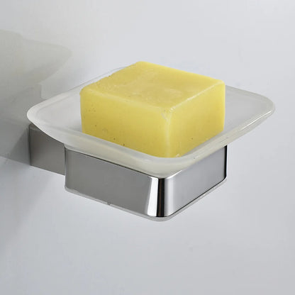 Wall-mounted chrome soap dish with frosted glass tray holding a yellow artisan bar soap, mounted on white wall
