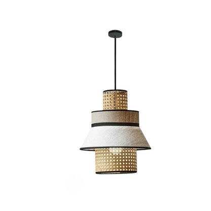 "Layer & Loom" tiered rattan and linen pendant light with alternating woven rattan and white linen rings, matte black frame, white background