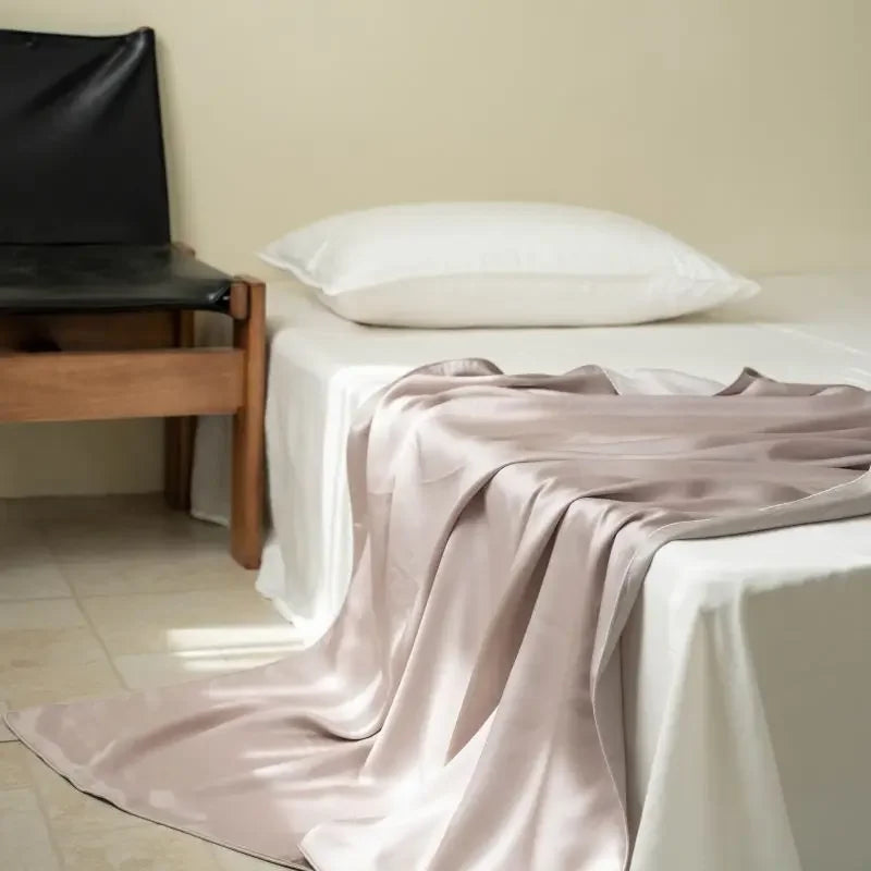  Blush Taupe 100% Tencel cooling summer blanket draped over a bed in a minimalist bedroom