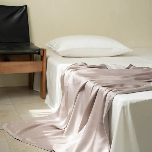  Blush Taupe 100% Tencel cooling summer blanket draped over a bed in a minimalist bedroom