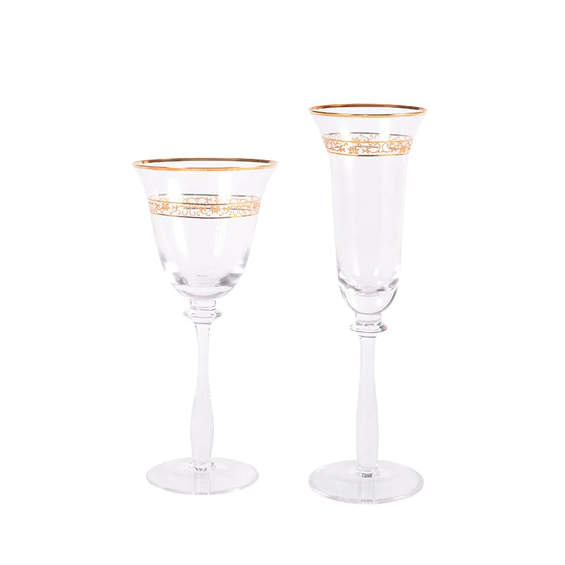 Two crystal glasses with gold filigree rim displayed on a leather and brass tray against a grey velvet sofa — CL House Golden Filigree collection