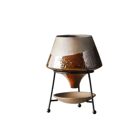  Amber reactive glaze ceramic cone plant pot on matte black iron tripod stand with ceramic drainage saucer, rich brown and silver glaze detail, grey background