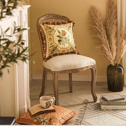 Golden Tassel botanical cushion cover styled on a carved French chair beside a fireplace and pampas grass — CL House & Home