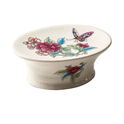 Oval pedestal ceramic soap dish with pink peony and butterfly chinoiserie print, crackle-glaze finish, angled view on white background
