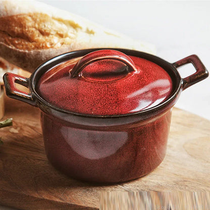  Crimson Ember ceramic casserole with lid, styled on rustic wooden board with artisan bread in background, deep burgundy reactive glaze with dark rim — Stone Vessel by CL House