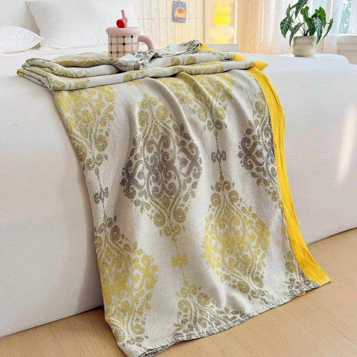  Golden Damask bamboo fibre jacquard blanket draped over a white bed frame, featuring an ornate baroque damask pattern in golden yellow tones with a solid yellow border trim