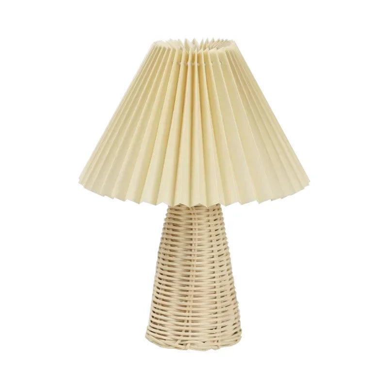 : Rattan & Pleat table lamp with natural woven rattan cone base and off-white pleated fabric shade, unlit product shot on a white background