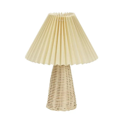 : Rattan & Pleat table lamp with natural woven rattan cone base and off-white pleated fabric shade, unlit product shot on a white background