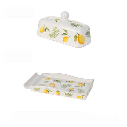 Lemon-patterned ceramic butter dish shown disassembled — domed lid and rectangular tray displayed separately on a white background, showing the full design detail.