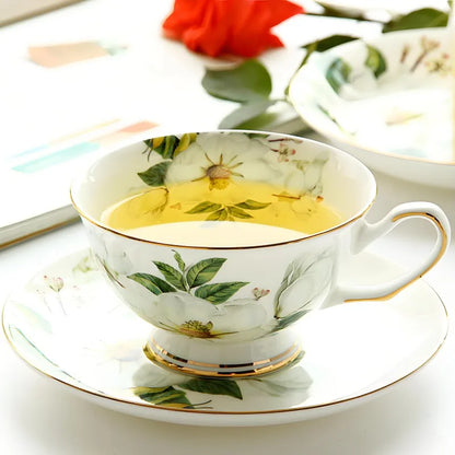 "White Camellia" fine bone china tea cup filled with golden tea, styled with a red rose — CL House & Home