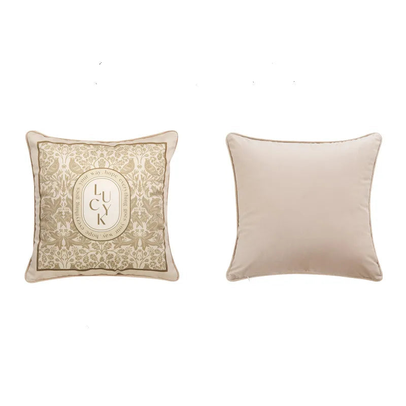 "Lucky Bloom" botanical velvet square cushion cover front and back view, warm beige ground with golden floral damask and typographic LUCK medallion, plain cream velvet reverse — CL House Cushions collection