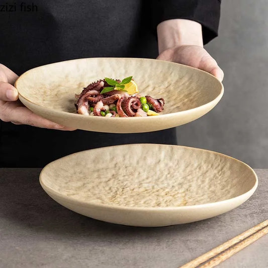 Handcrafted ceramic dinner plate with hammered stone texture held by a chef, styled with gourmet food