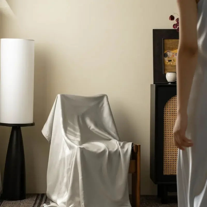 : Pearl Silver 100% Tencel cooling summer blanket draped over an armchair in a styled living room