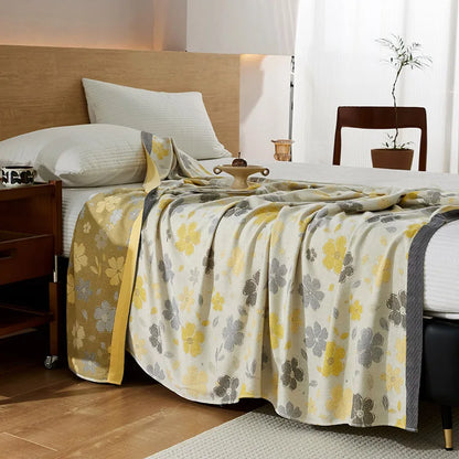 "100% Bamboo Fibre cooling blanket in Golden Bloom — ivory cream with yellow and grey floral print and golden yellow border, lightweight summer throw styled on a bed"