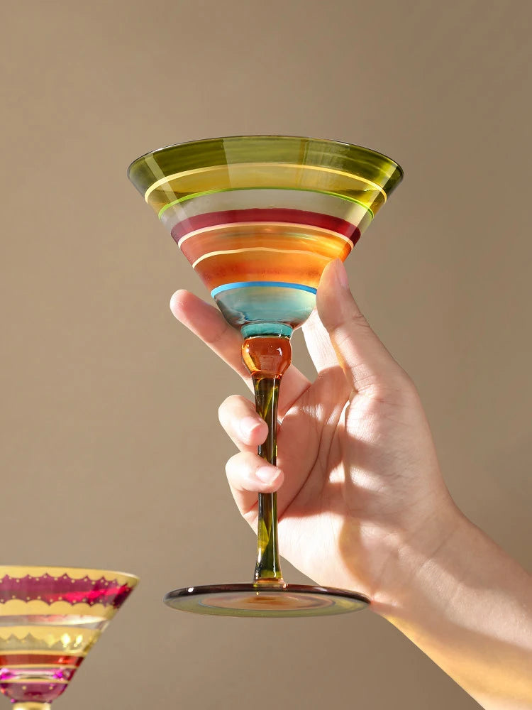  Hand holding a "Chromatic" hand-painted martini glass in Carnival variant — CL House Drinkware collection