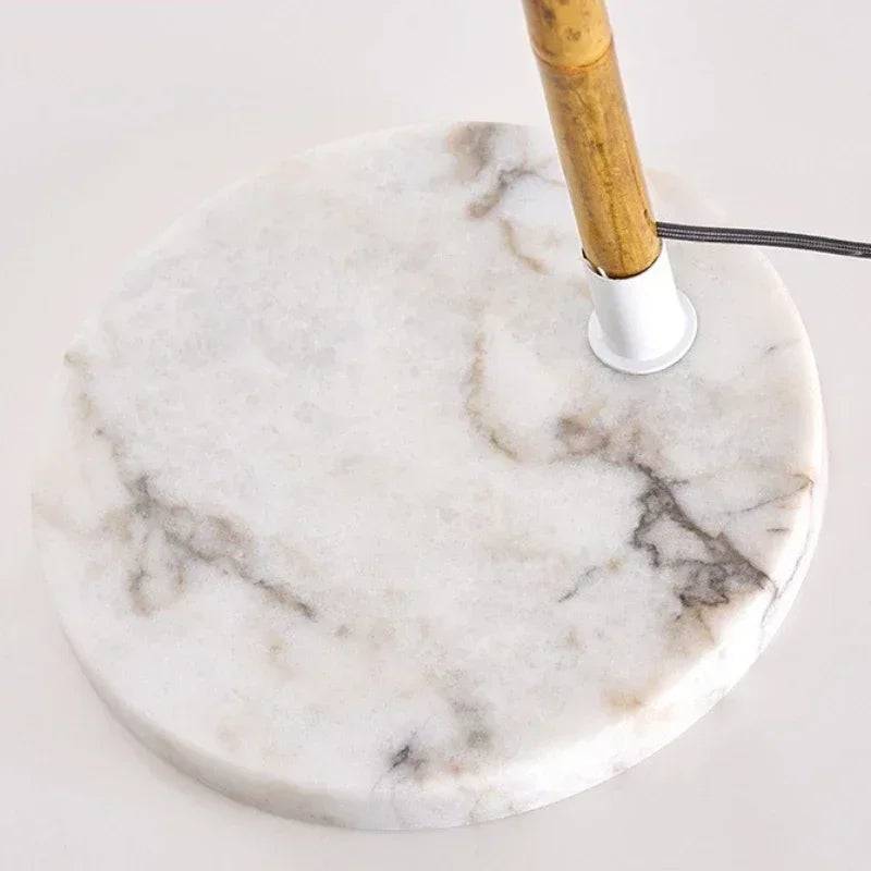 Close-up of the Arc & Pleat floor lamp solid marble base with natural grey veining and bamboo-finish pole detail