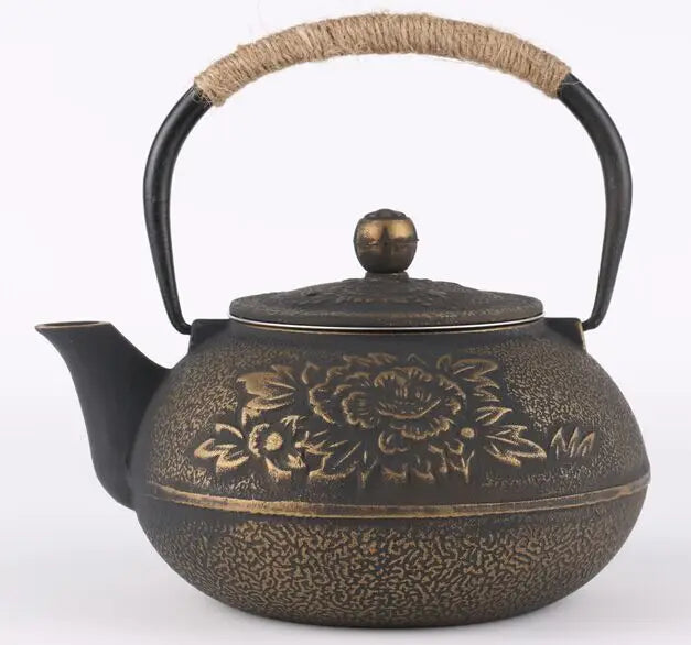  Cast iron teapot, Ancient Bronze finish — hand-engraved peony blossoms on warm bronze patina, rope-wrapped handle, round bronze lid knob, white background — Iron Ritual by CL House