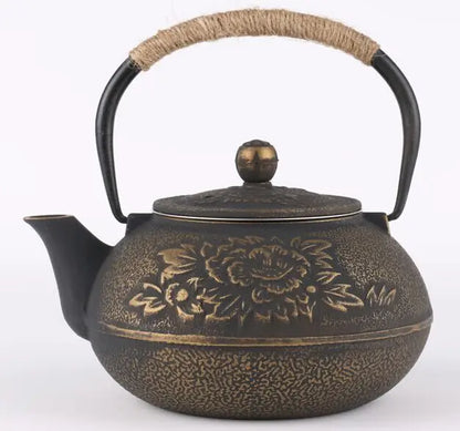  Cast iron teapot, Ancient Bronze finish — hand-engraved peony blossoms on warm bronze patina, rope-wrapped handle, round bronze lid knob, white background — Iron Ritual by CL House