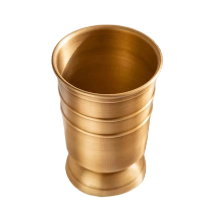 Antique brass bathroom tumbler cup with ridged body and flared rim, brushed warm gold finish, white background