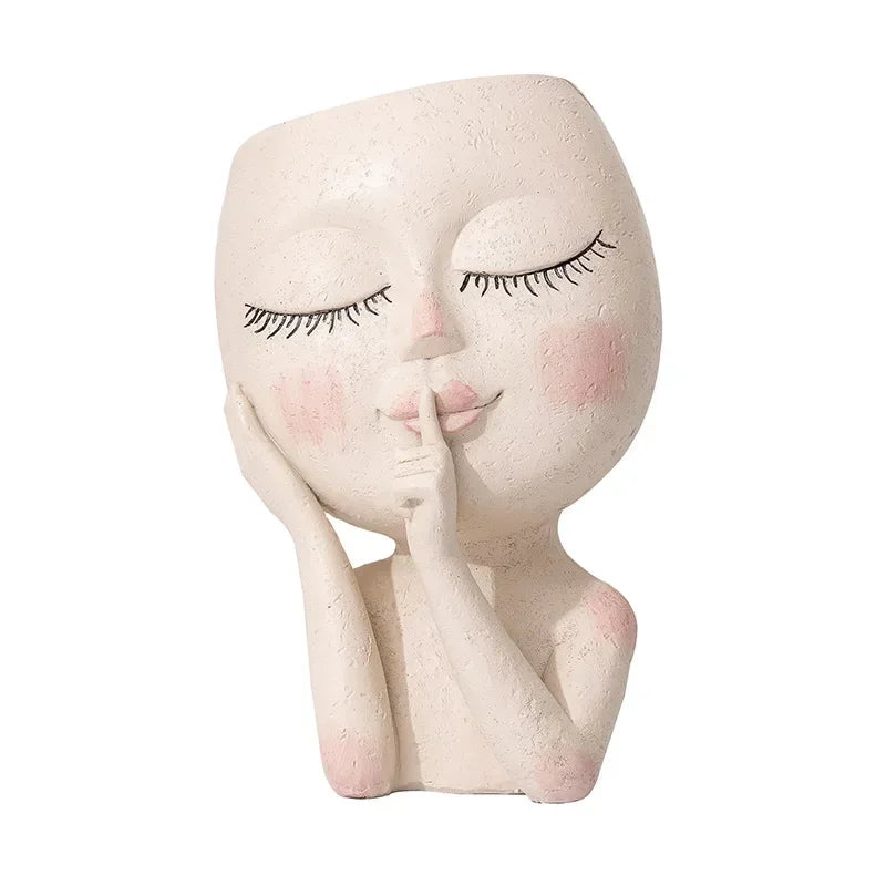 Hush Muse" sculptural face resin planter in ivory cream with closed eyes, rosy cheeks and shh finger gesture, full body view, white background