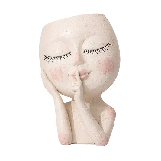 Hush Muse" sculptural face resin planter in ivory cream with closed eyes, rosy cheeks and shh finger gesture, full body view, white background